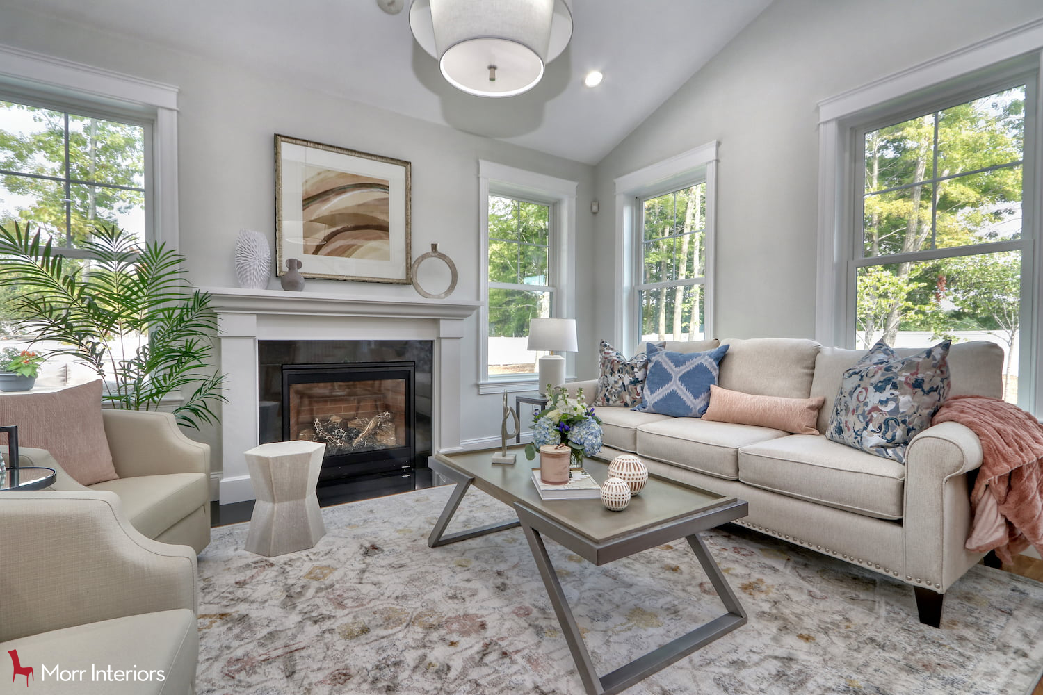 The family room of Blu Haven. A couch is on the right, in behind a coffee table. Two beige chairs are on the left, a fern at the back